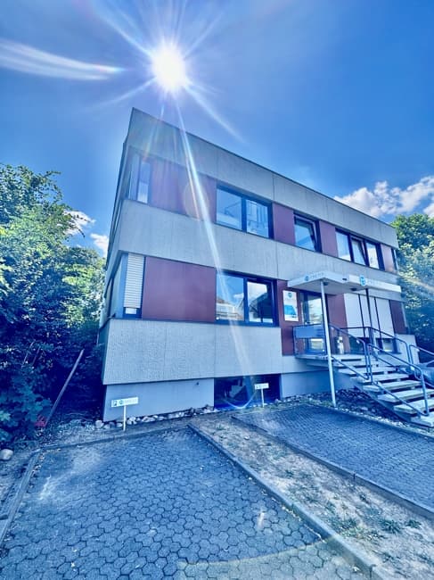 Dreigeschossiges Wohn- und Geschäftshaus in Sulzbach mit Außentreppe, im Gegenlicht